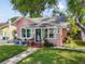 Charming pink home with a well-manicured lawn, white picket fence and inviting front porch seating area at 2330 7Th W Ave, Bradenton, FL 34205