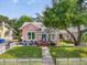 Charming pink home with a well-manicured lawn, white picket fence and inviting front porch seating area at 2330 7Th W Ave, Bradenton, FL 34205