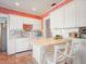 Classic kitchen with white cabinetry, terracotta tile, breakfast bar and stainless steel appliances at 2330 7Th W Ave, Bradenton, FL 34205