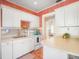 Cozy kitchen featuring white cabinets, warm terracotta tile flooring, and retro wallpaper at 2330 7Th W Ave, Bradenton, FL 34205