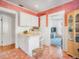 Charming kitchenette features white cabinetry, terracotta flooring, breakfast bar, and pantry at 2330 7Th W Ave, Bradenton, FL 34205