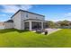 View of the home's exterior with a large, covered patio with seating and a fire pit at 2332 Mizner Bay Ave, Bradenton, FL 34208