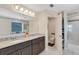 Bathroom featuring double sinks, a vanity with granite countertop, and open shower at 2332 Mizner Bay Ave, Bradenton, FL 34208