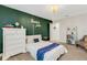 Bedroom with decorative green wall and white furniture, adjacent to an open door at 2332 Mizner Bay Ave, Bradenton, FL 34208