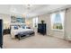 Spacious main bedroom with a tray ceiling, large windows, and stylish navy blue furniture at 2332 Mizner Bay Ave, Bradenton, FL 34208