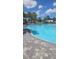 Beautiful community pool with blue water, well-manicured landscaping and palm trees at 2332 Mizner Bay Ave, Bradenton, FL 34208