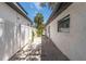 Narrow side yard with gravel, stepping stones, and a white fence at 2410 Floyd St, Sarasota, FL 34239