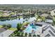 Aerial view of a community with a pool, tennis courts, and a lake surrounded by houses at 2631 Sapphire Blue Ln, Bradenton, FL 34211