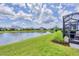 Lush green backyard with a peaceful lake view and screened-in patio at 2631 Sapphire Blue Ln, Bradenton, FL 34211