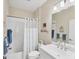 Bright bathroom featuring a shower-tub combination, neutral tile, and a single sink vanity at 2631 Sapphire Blue Ln, Bradenton, FL 34211