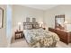 Comfortable bedroom with a patterned bedspread, wooden furniture, and neutral colored walls at 2631 Sapphire Blue Ln, Bradenton, FL 34211