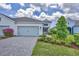Beautiful home featuring paver driveway, pristine landscaping, and soft blue garage doors at 2631 Sapphire Blue Ln, Bradenton, FL 34211