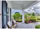 Inviting front porch features cozy seating and meticulous landscaping at 2631 Sapphire Blue Ln, Bradenton, FL 34211