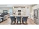 Bright kitchen featuring a quartz island with seating, white cabinets, and stainless steel refrigerator at 2631 Sapphire Blue Ln, Bradenton, FL 34211