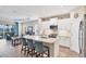 Open kitchen with a large island, seating, white cabinets, and stainless steel appliances at 2631 Sapphire Blue Ln, Bradenton, FL 34211