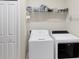 Functional laundry room featuring a washer, dryer, shelving, and a nearby closet at 2631 Sapphire Blue Ln, Bradenton, FL 34211
