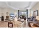 Comfortable living room with tray ceilings, wood floors, and views of the backyard pond at 2631 Sapphire Blue Ln, Bradenton, FL 34211
