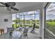 Relaxing screened-in patio with comfortable seating and a ceiling fan overlooking a beautiful pond and green space at 2631 Sapphire Blue Ln, Bradenton, FL 34211