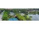 Aerial view of tennis courts next to a lake with green trees and houses in a residential community at 2631 Sapphire Blue Ln, Bradenton, FL 34211