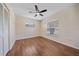 Bedroom with wood-look flooring, ceiling fan, closet, and a window offering natural light at 2953 Oak St, Sarasota, FL 34237