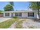 Single-story home features a gray exterior, dark shutters, and manicured lawn at 2953 Oak St, Sarasota, FL 34237