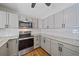 Updated kitchen features stainless steel appliances, granite counters, and modern grey cabinets at 2953 Oak St, Sarasota, FL 34237