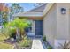 Close-up of the home's front door with decorative landscaping including palm trees and flower beds at 3429 97Th E Ln, Palmetto, FL 34221