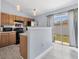 Bright kitchen with wood cabinets, appliances, light fixtures, and sliding glass door to the yard at 3429 97Th E Ln, Palmetto, FL 34221