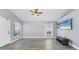 Spacious living room with wood-look floors, a ceiling fan, and a large window for plenty of sunlight at 3429 97Th E Ln, Palmetto, FL 34221