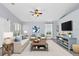 Bright, staged living room with a ceiling fan, large windows, and modern decor throughout at 3429 97Th E Ln, Palmetto, FL 34221