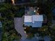 An aerial view of a house with a pool, spa, putting green, and brick driveway surrounded by lush tropical foliage at 3446 Anglin Dr, Sarasota, FL 34242