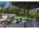 Backyard with lounge chairs, patio seating, putting green, white fence, and lush landscaping at 3446 Anglin Dr, Sarasota, FL 34242