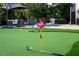 Backyard with putting green, patio, seating, pool, landscaping and the exterior of the home at 3446 Anglin Dr, Sarasota, FL 34242