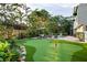 Backyard with pool, putting green, patio, lounge chairs and lush landscaping at 3446 Anglin Dr, Sarasota, FL 34242