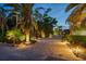 Paver driveway leading to the house surrounded by tropical landscaping at twilight at 3446 Anglin Dr, Sarasota, FL 34242