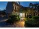 Charming front entrance with a brick walkway, lush landscaping, and inviting exterior lighting at twilight at 3446 Anglin Dr, Sarasota, FL 34242