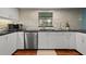 Updated kitchen features stainless steel appliances, white cabinetry, and tile backsplash at 3446 Anglin Dr, Sarasota, FL 34242