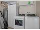 Well-equipped laundry room with modern washer and dryer, storage cabinet, and utility sink at 3446 Anglin Dr, Sarasota, FL 34242