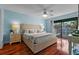 Comfortable main bedroom featuring a king-size bed, neutral tones, and a private balcony overlooking lush greenery at 3446 Anglin Dr, Sarasota, FL 34242