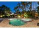 Backyard pool and spa area with lounge chairs, patio seating and surrounding palm trees create a relaxing oasis at dusk at 3446 Anglin Dr, Sarasota, FL 34242