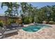 Backyard pool with outdoor seating, spa, brick patio, lush landscaping, and grilling area for outdoor entertaining at 3446 Anglin Dr, Sarasota, FL 34242