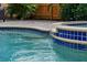Relaxing waterfall feature enhances this backyard pool and spa surrounded by attractive tile and stone work at 3446 Anglin Dr, Sarasota, FL 34242