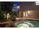 Backyard pool and spa, with nearby grill and patio lead to a second story screened porch at twilight at 3446 Anglin Dr, Sarasota, FL 34242