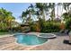 Backyard pool and spa area with lounge chairs, patio seating and surrounding palm trees create a relaxing oasis at 3446 Anglin Dr, Sarasota, FL 34242