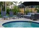 Backyard pool and spa area with lounge chairs, patio seating and putting green at 3446 Anglin Dr, Sarasota, FL 34242