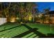 Backyard putting green at night with lush landscaping and lighting at 3446 Anglin Dr, Sarasota, FL 34242