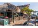 Inviting sidewalk café with thatched roof, patrons, and a pleasant view of the street at 3446 Anglin Dr, Sarasota, FL 34242