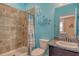 Cozy bathroom featuring tiled shower, granite countertop sink and coastal décor at 364 Grande Vista Blvd, Bradenton, FL 34212