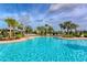 Inviting community pool surrounded by palm trees and lounge chairs, offering a refreshing oasis for residents at 364 Grande Vista Blvd, Bradenton, FL 34212