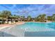 Luxurious community pool area with ample lounge chairs, pergolas, and tropical landscaping at 364 Grande Vista Blvd, Bradenton, FL 34212